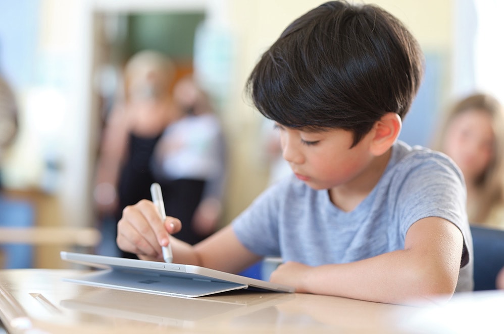 Uczeń używa pióra Surface do pisania na urządzeniu Surface Go