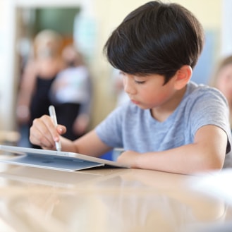 A student uses a Surface Pen to write on his Surface Go