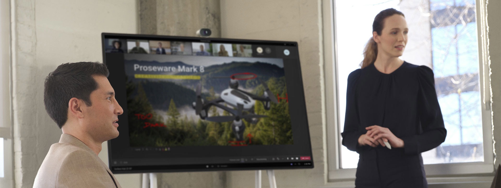 Nainen seisoo Surface Hubin edessä esitellessään PowerPoint-asiakirjaa virtuaalisessa Teams-puhelussa