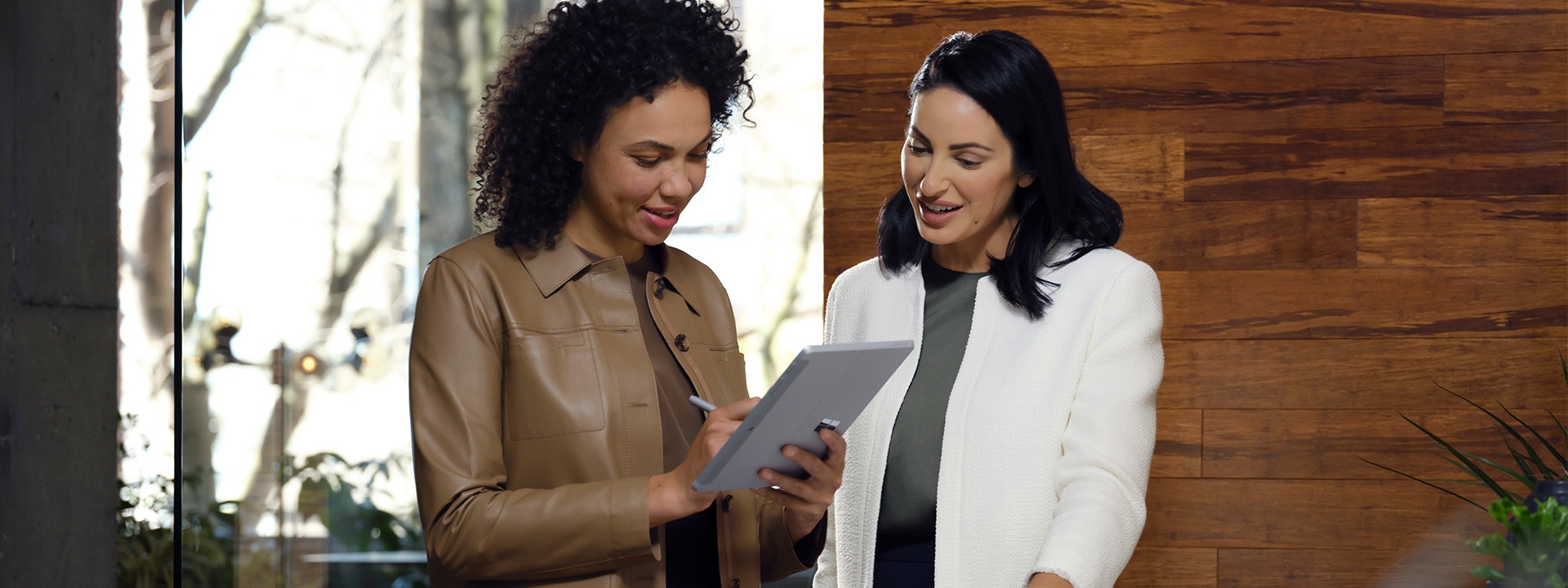 Kaksi työtoveria tekee yhteistyötä Surface Go 3:n parissa toimistossa