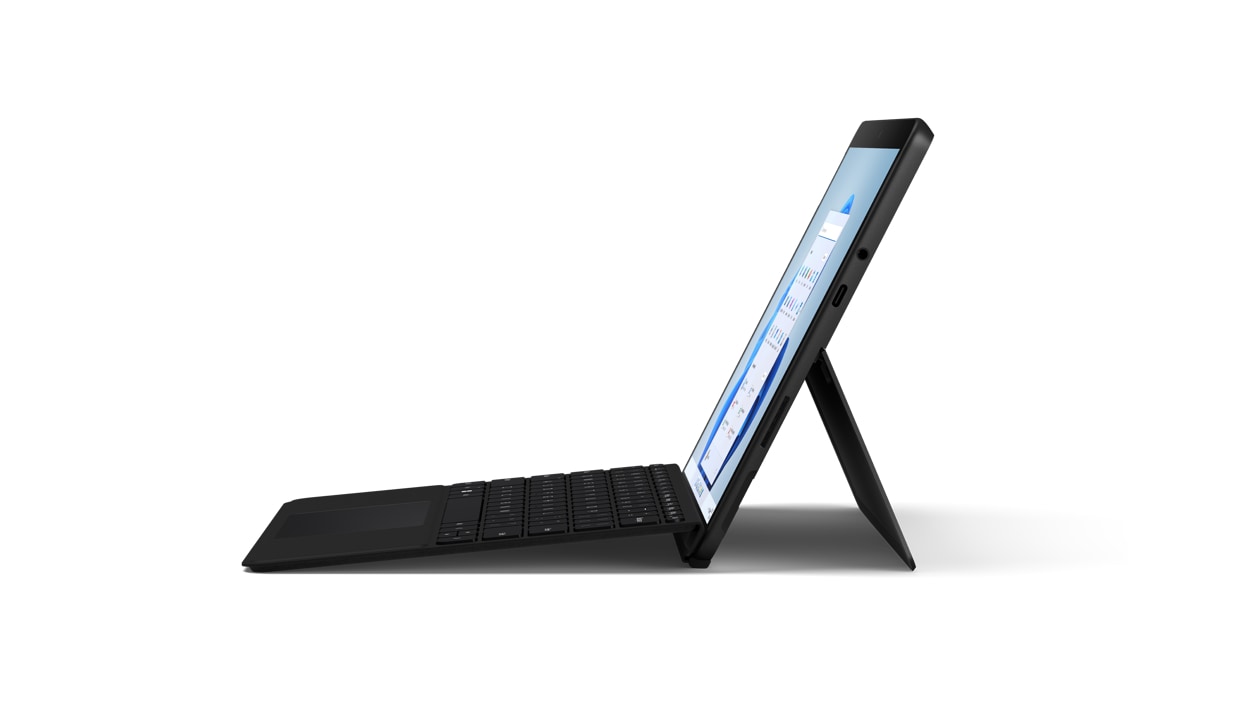 Vista lateral del Surface Go 3 en color negro mate, ilustrado en modo portátil con una funda con teclado Surface.