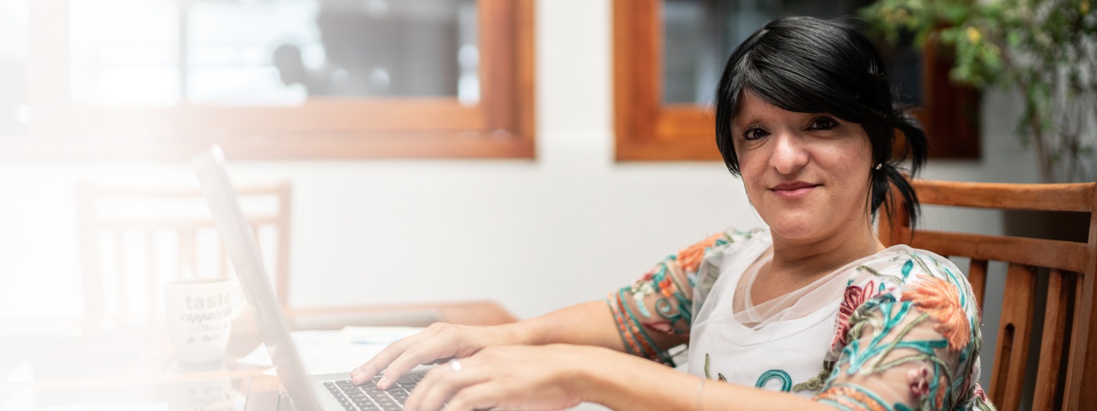 Une femme utilisant un ordinateur portable et travaillant chez elle
