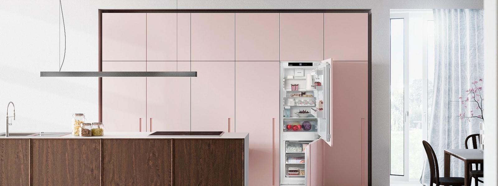 Das Bild zeigt eine Küche in rosa und Holzoptik mit einem Liebherr Kühlschrank