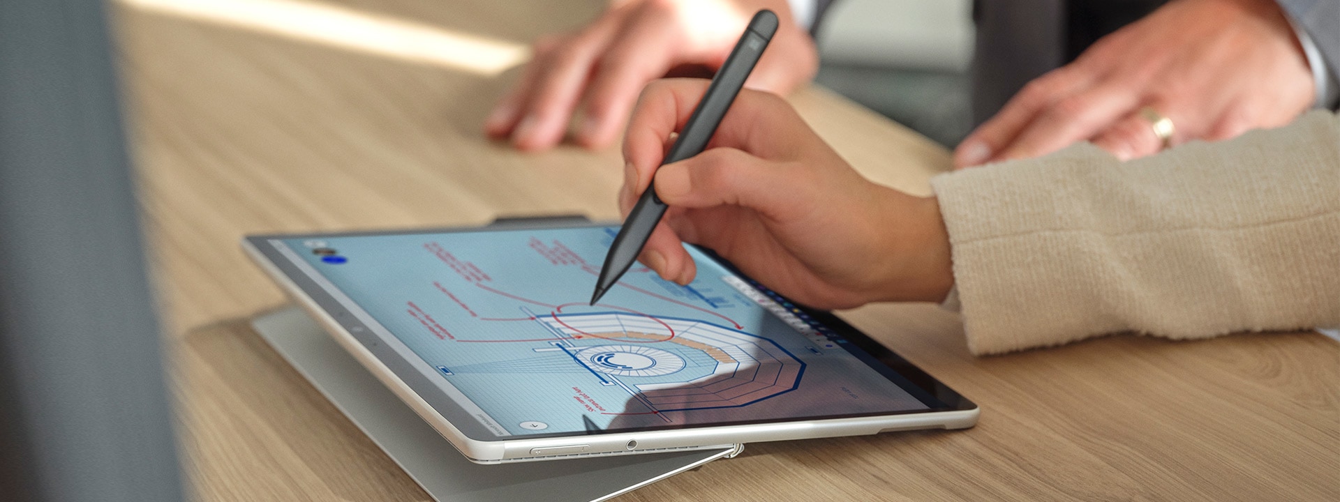  A person's hand is observed using Surface Slim Pen 2 on the screen of Surface Pro 8