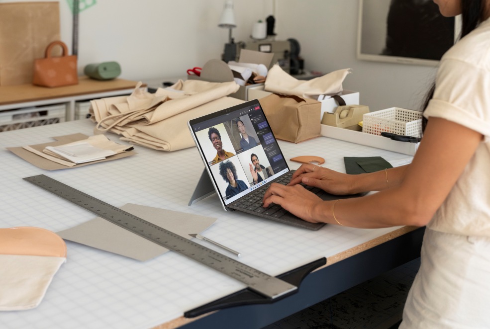 Frau im Büro mit Surface Pro X bei einem Microsoft Team-Meeting