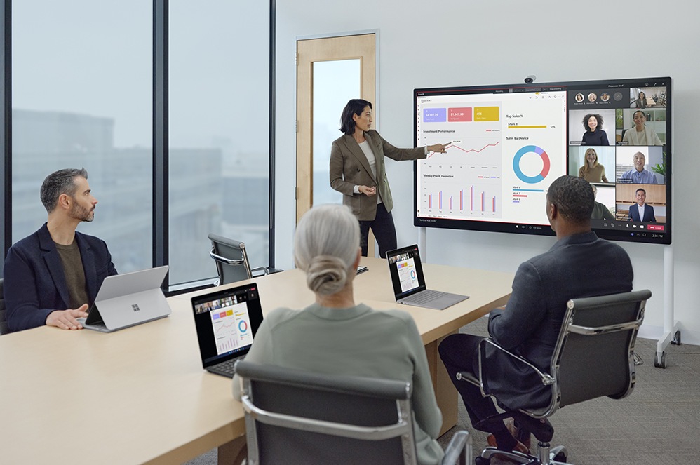 Les employés présents au bureau et ceux à distance regardent une présentation ensemble avec Microsoft Teams à l’aide de la Caméra intelligente pour Surface Hub 2 et du Surface Hub 2S pour les entreprises.
