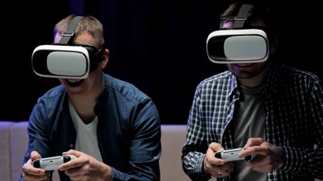 Two people wearing virtual reality headsets playing games together.