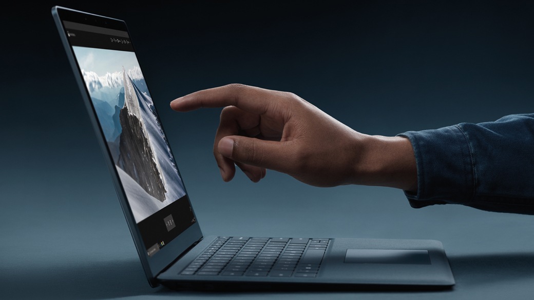 Person about to touch the touchscreen on a Surface Laptop