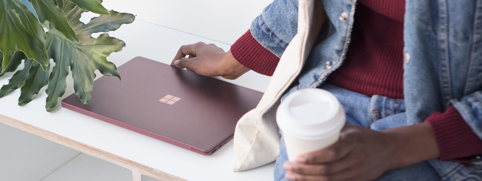 A person picking up a Surface Laptop