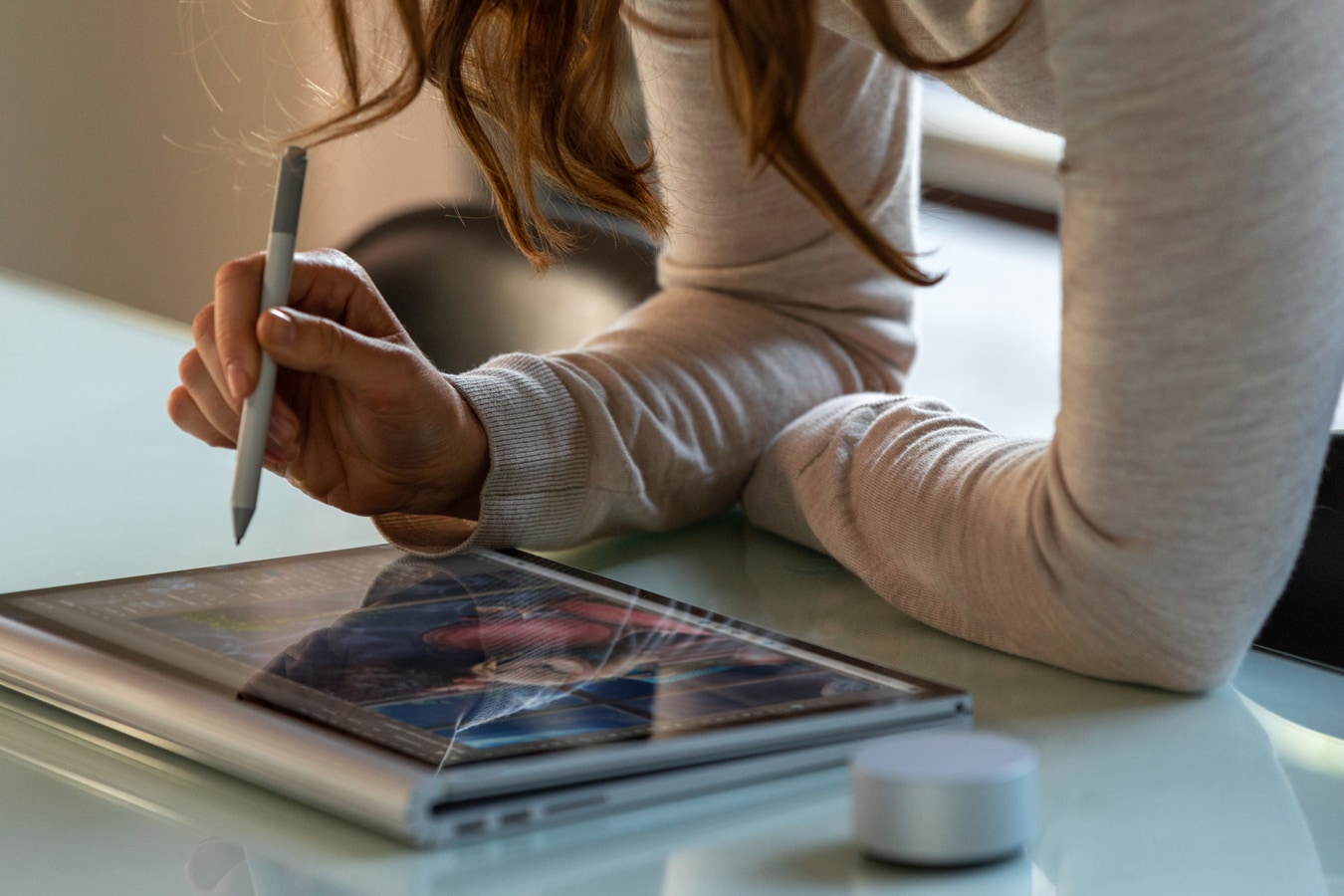 En kvinne bruker Surface Book 3 som et nettbrett med Surface-penn og Surface Dial