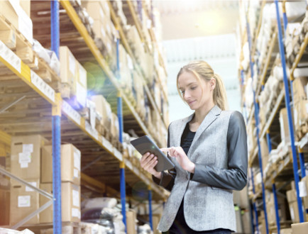 A person in a warehouse holding a tablet