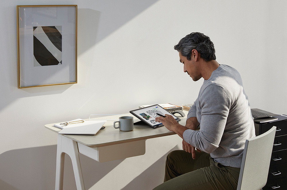 Un uomo al lavoro da casa usa la Penna per Surface sul suo computer Surface Pro