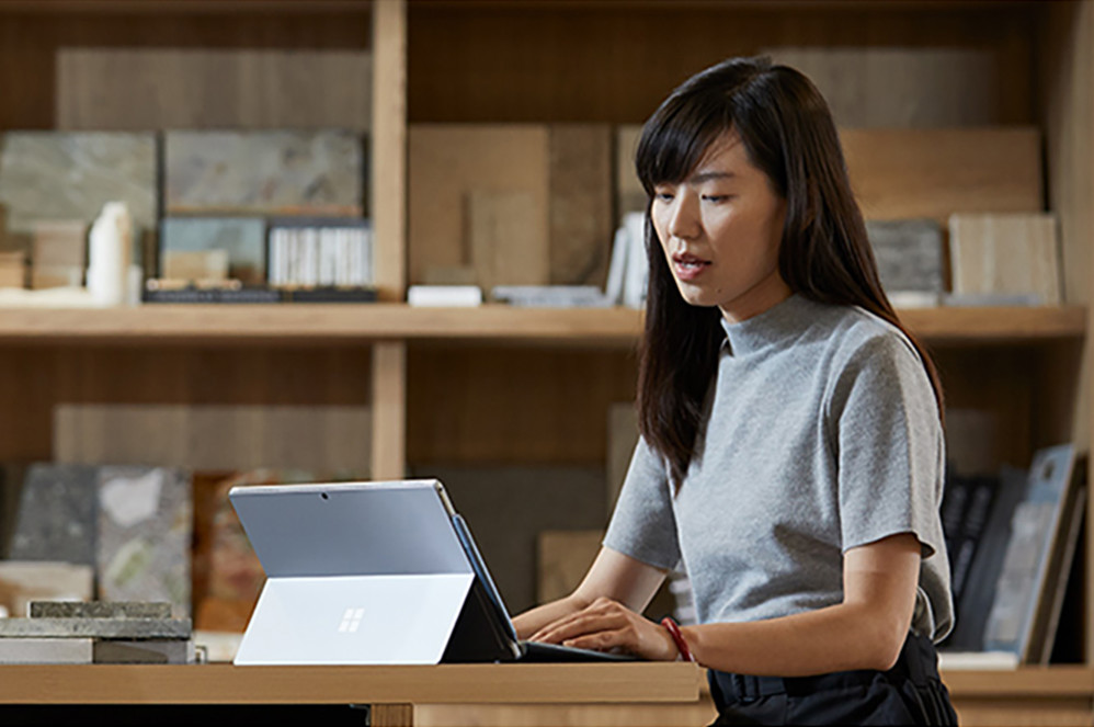 Una persona lavora con il suo dispositivo Surface in un ambiente d'ufficio